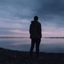 pexels photo 670720 670720 A solitary silhouette of a man in a jacket gazing at a lake during a peaceful sunset, creating a serene atmosphere.